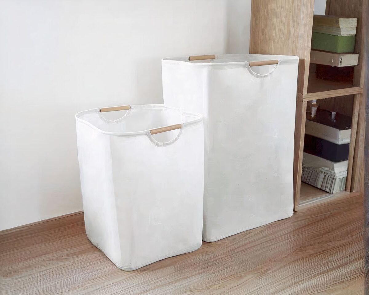 On voit deux paniers à linge en coton, un grand et un plus petit, le long d'un mur.