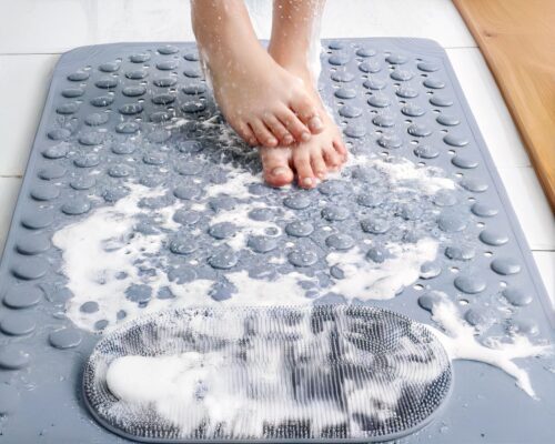 Tapis de bain gris avec pieds posés dessus.