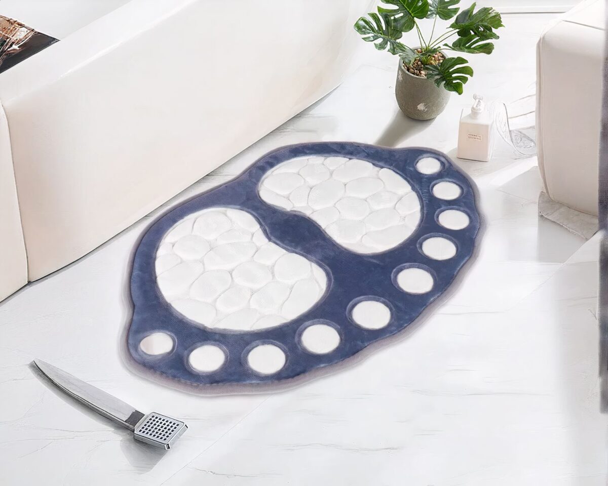 Tapis de bain bleu et blanc en forme de pied devant une baignoire dans une salle de bain