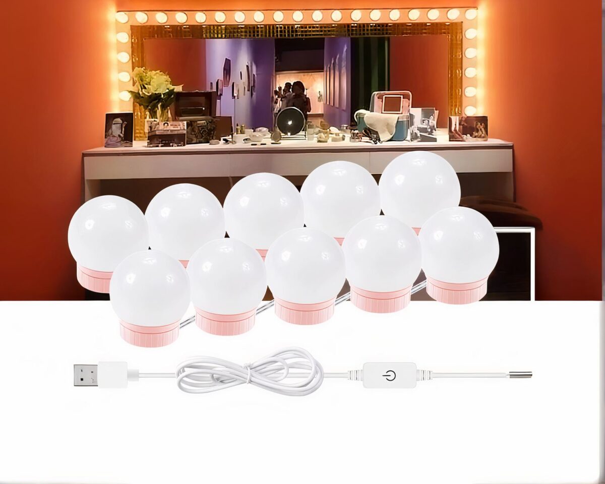 Photo dé 10 ampoules au pied rose à connexion USB présentées devant un grand miroir de maquillage orné des lampes allumées sur un mur orange au fond