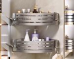 Photo de deux étagères de douche d'ange murales garnies de produits et installées l'une au dessus de l'autre sur un angle de mur de salle de bain beige