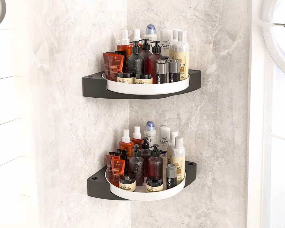 Photo de deux étagères de douche d'angle blanches rotatives en plastique chargées de produits de beauté dans une salle de bain aux murs gris