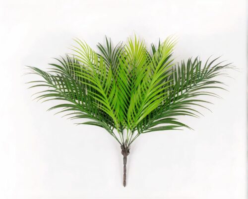 Bouquet de feuilles artificielles tropicales sur fond gris.