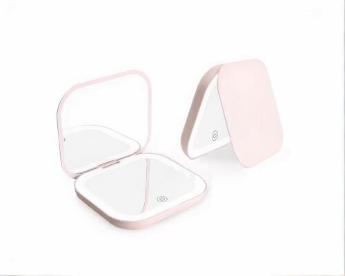 Miroir de poche rose sur fond blanc.