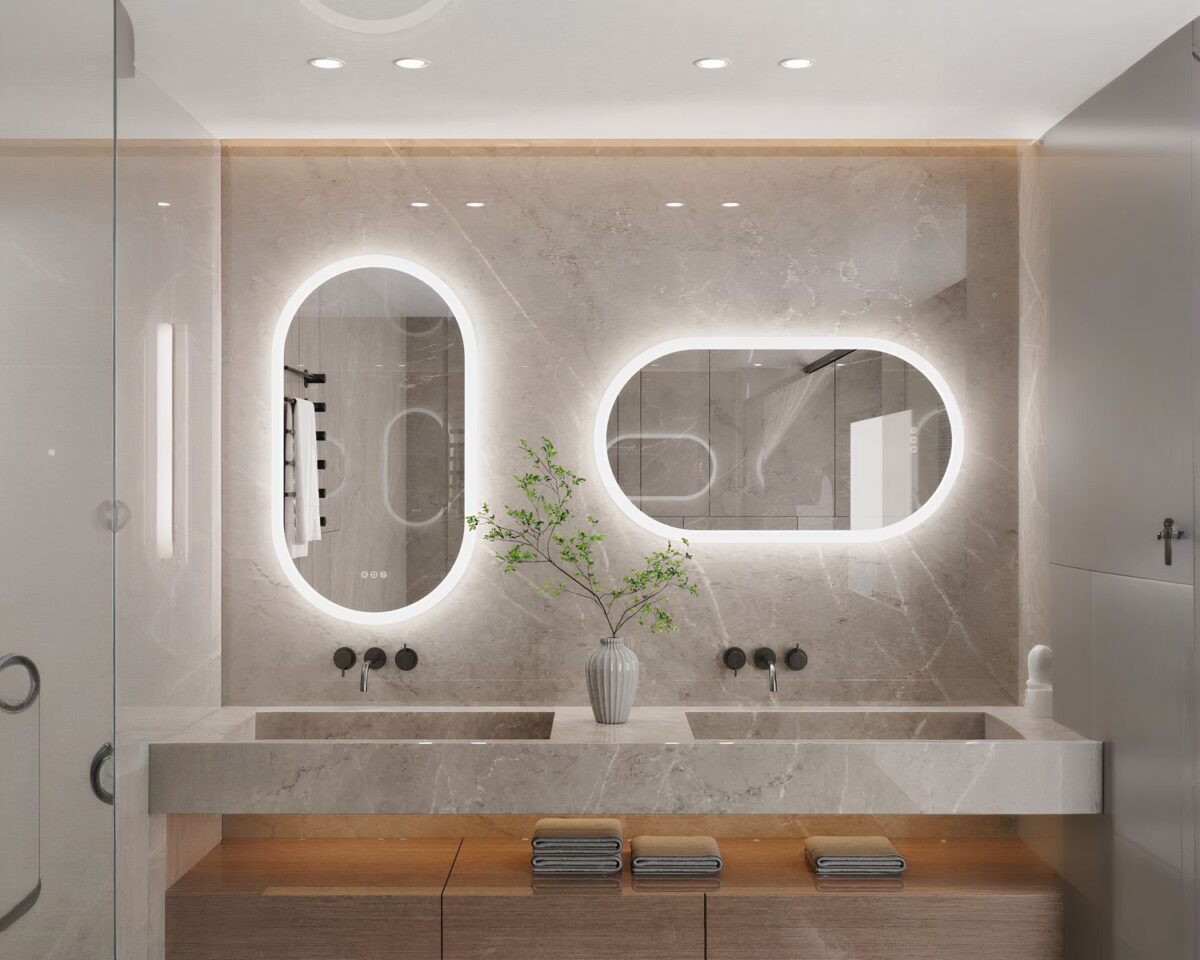 On voit deux miroirs ovales au-dessus d'une vasque de salle de bain.