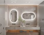On voit deux miroirs ovales au-dessus d'une vasque de salle de bain.