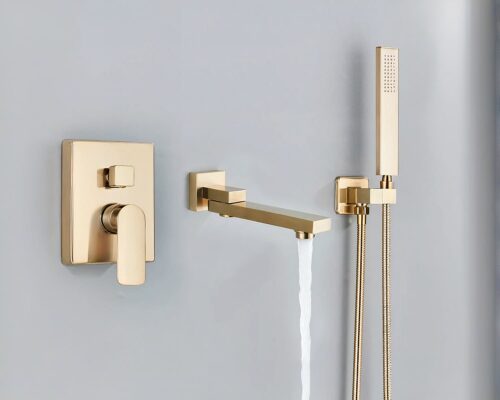 Photo d'un mitigeur salle de bain doré en trois parties avec l'eau qui coule du bec pivotant, le mitigeur à gauche et la doucette à droite le tout sur un mur gris