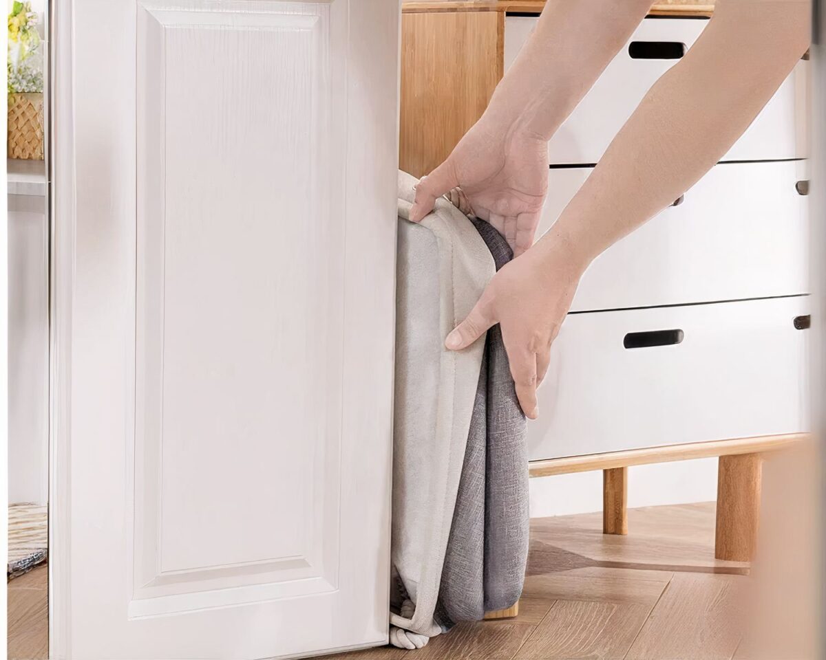 On voit un panier à linge gris et noir, design avec des poignées en corde.