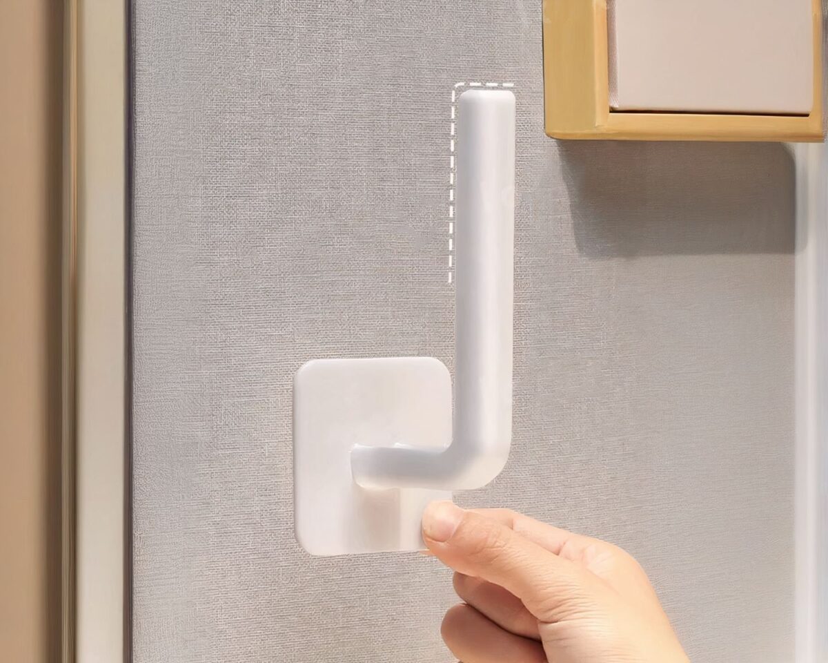 Patère autocollante blanche sur fond gris.