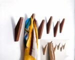 Ensemble de patères en bois foncé et clair avec un foulars accroché