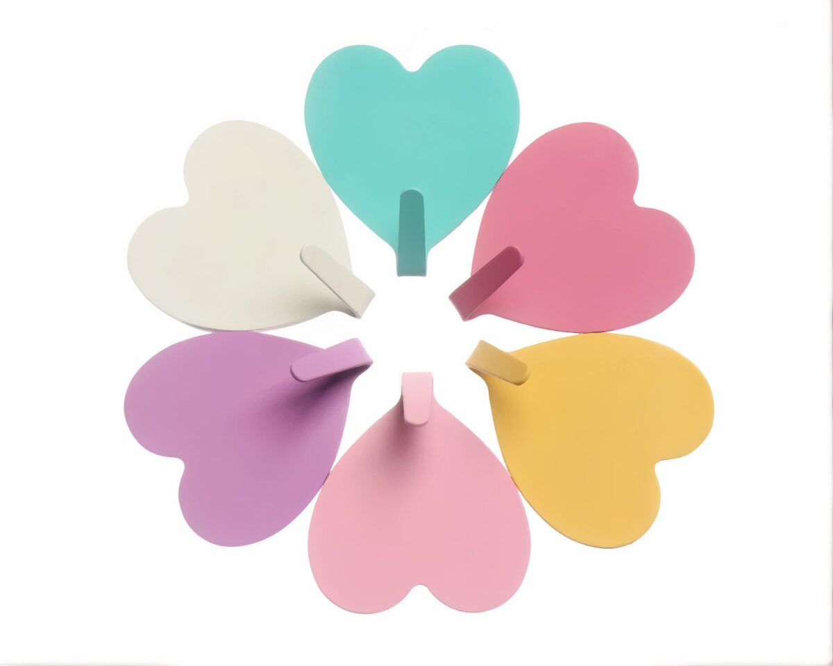 Plusieurs patères murales en forme de coeur sur fond blanc.