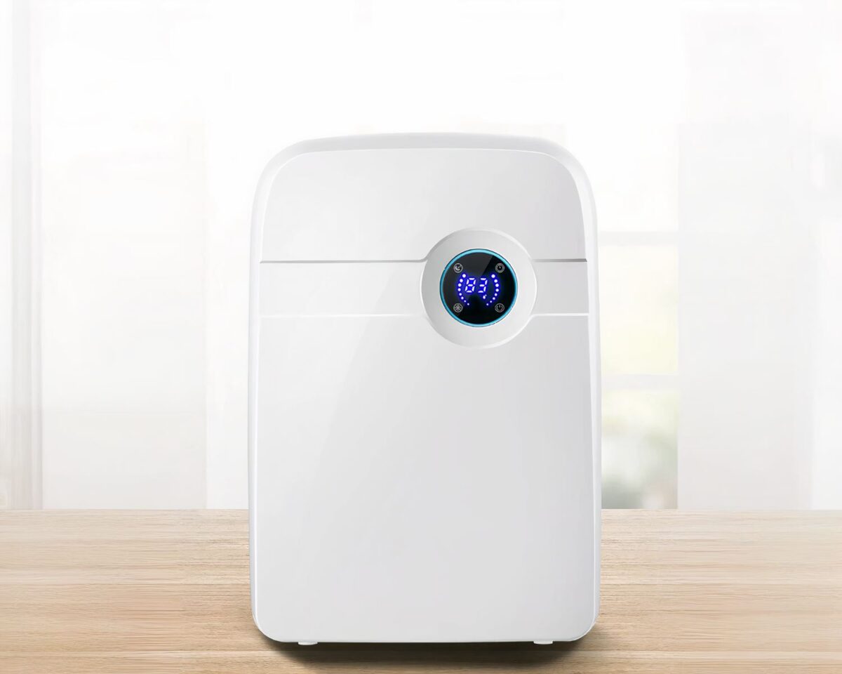Photo d'un déshumidificateur blanc avec écran LCD sur un sol en bois clair devant un fond blanc