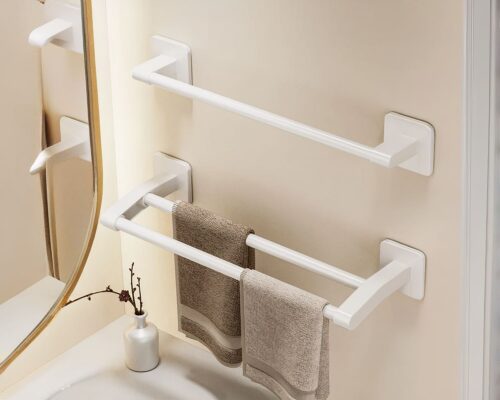 On voit deux porte-serviettes blanc : un avec une barre simple, l'autre avec deux barres. Ils sont installés au mur près d'un miroir.