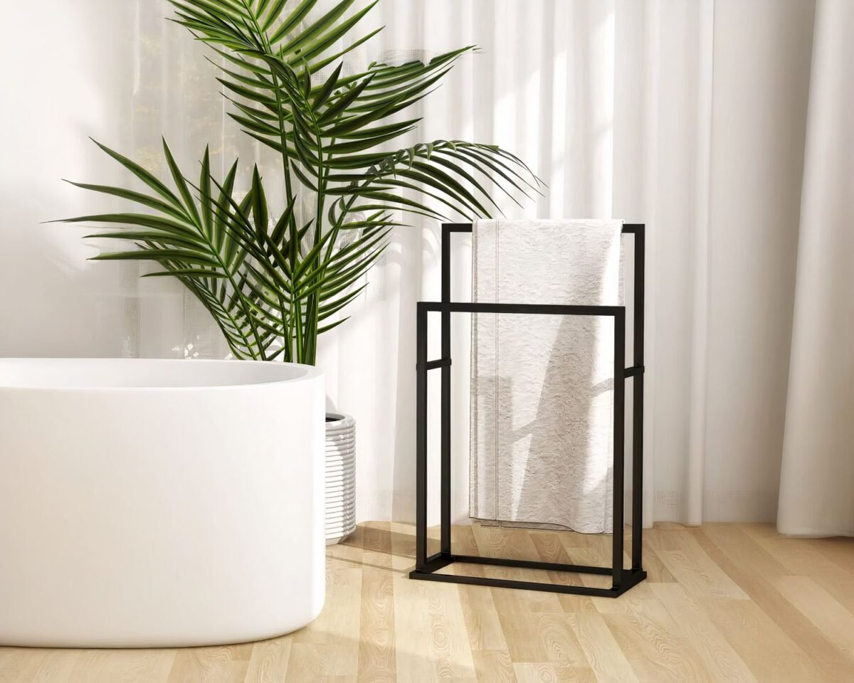 Porte serviette sur pied noir graphique devant rideau et plante