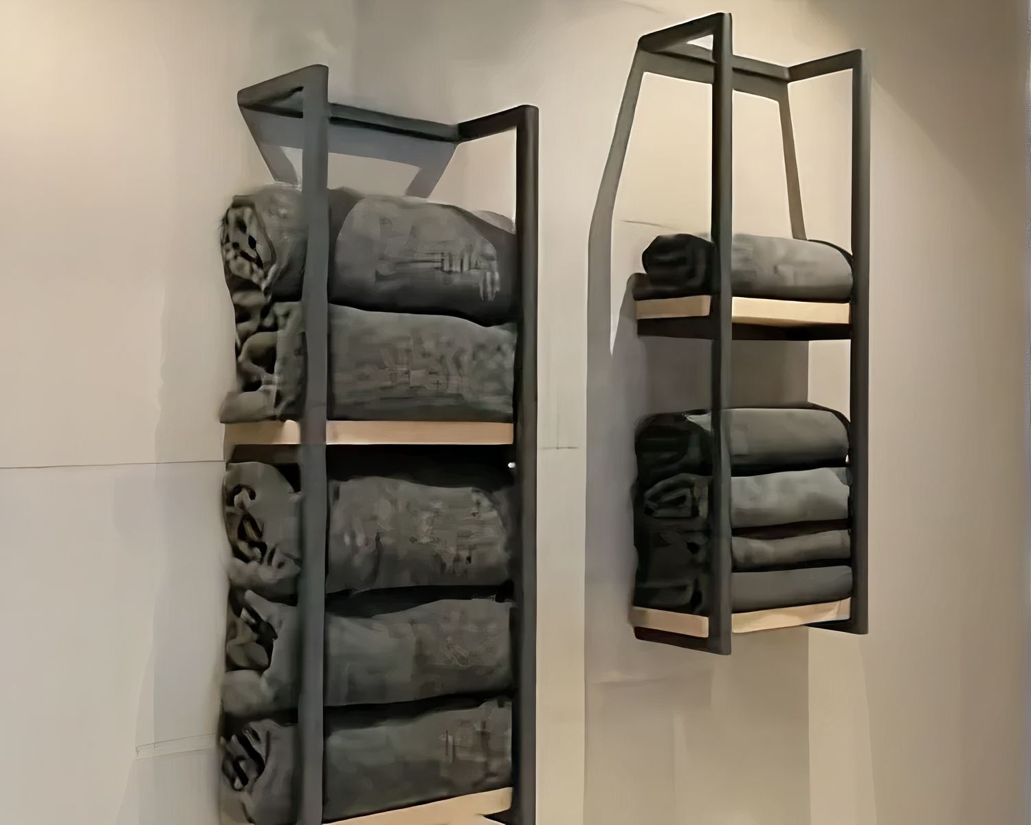 Rangement serviettes salle de bain murale noir et bois, deux tablettes avec des serviettes, sur un mur beige.