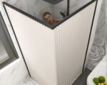 Rideau de douche beige en angle avec une personne prenant sa douche.