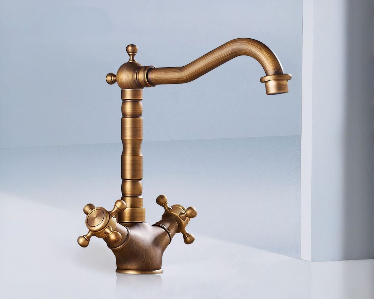 Photo d'un robinet de salle de bain de style rétro à deux poignées couleur bronze avec une grande tige puis un bec verseur horizontal coudé le tout sur un fond bleu