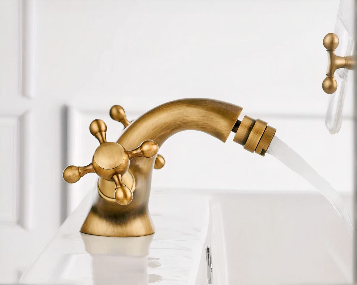 Photo d'un robinet de salle de bain couleur bronze mat ouvert avec une buse mobile au jet de bulles douces sur un lavabo blanc, le tout sur fond blanc