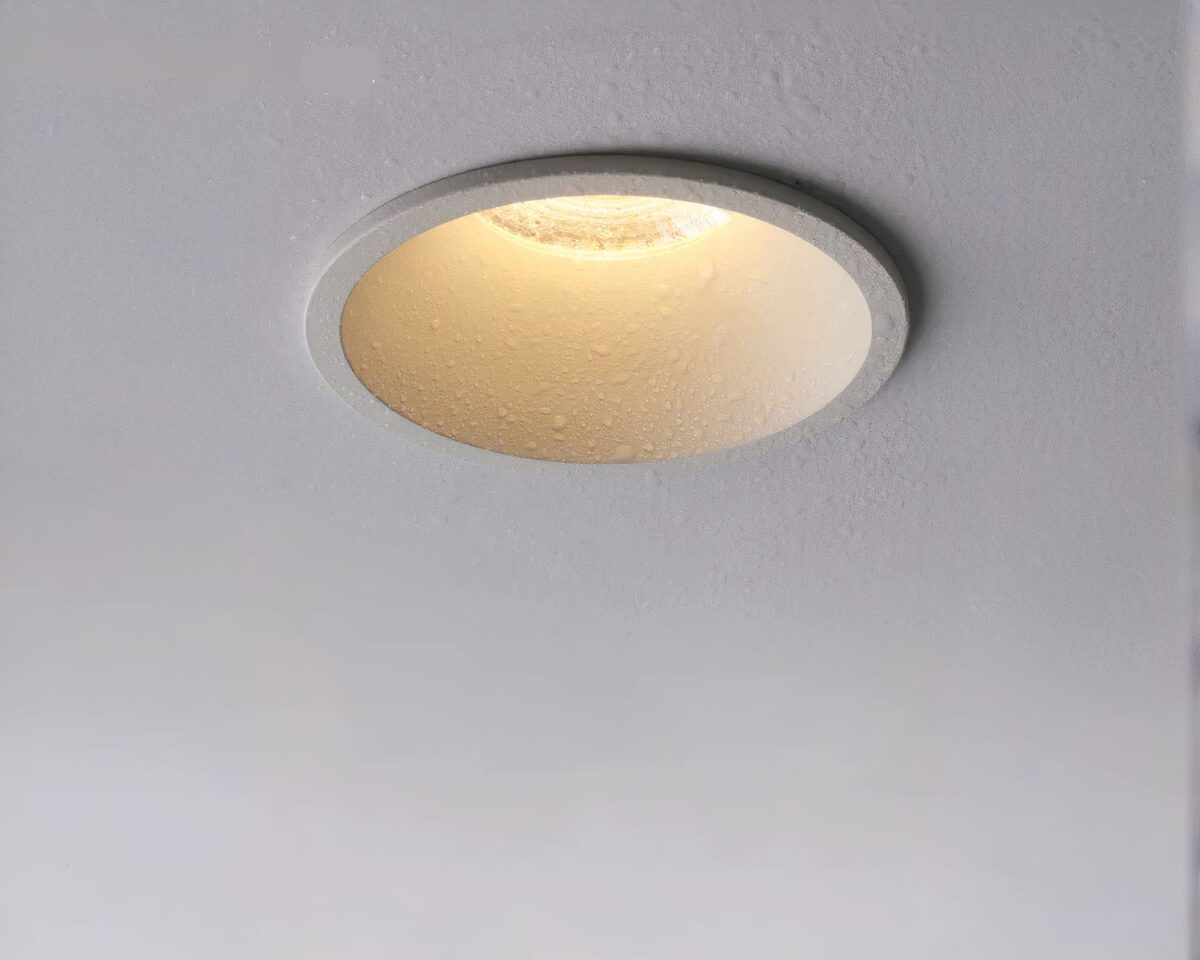 Photo d'un spot encastrable pour salle de bain au rebord ultra mince éclairé sur un plafond gris