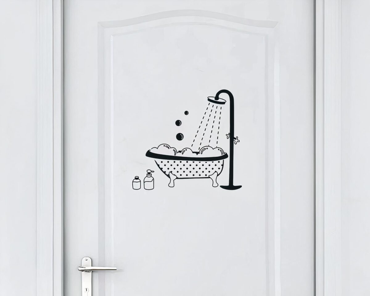 On voit une porte de salle de bain avec un stickers avec une baignoire pour annoncer la pièce
