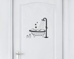 On voit une porte de salle de bain avec un stickers avec une baignoire pour annoncer la pièce