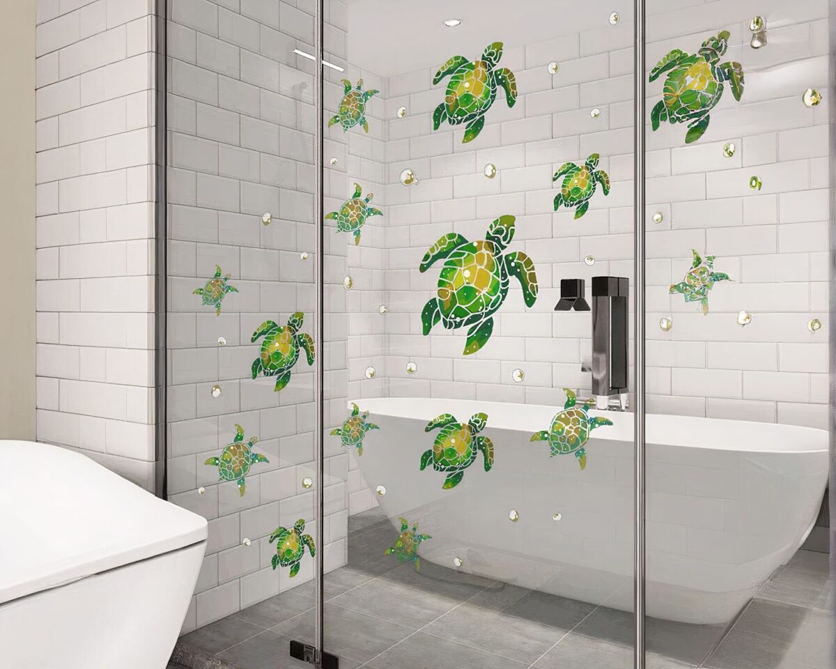 On voit une douche décorée de stickers muraux en forme de tortues vertes.