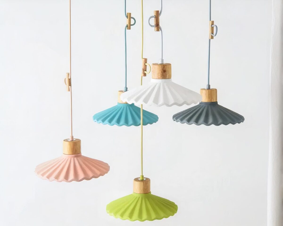 Photo représentant cinq suspensions colorées en pierre et bois à cordon réglable sur un fond blanc